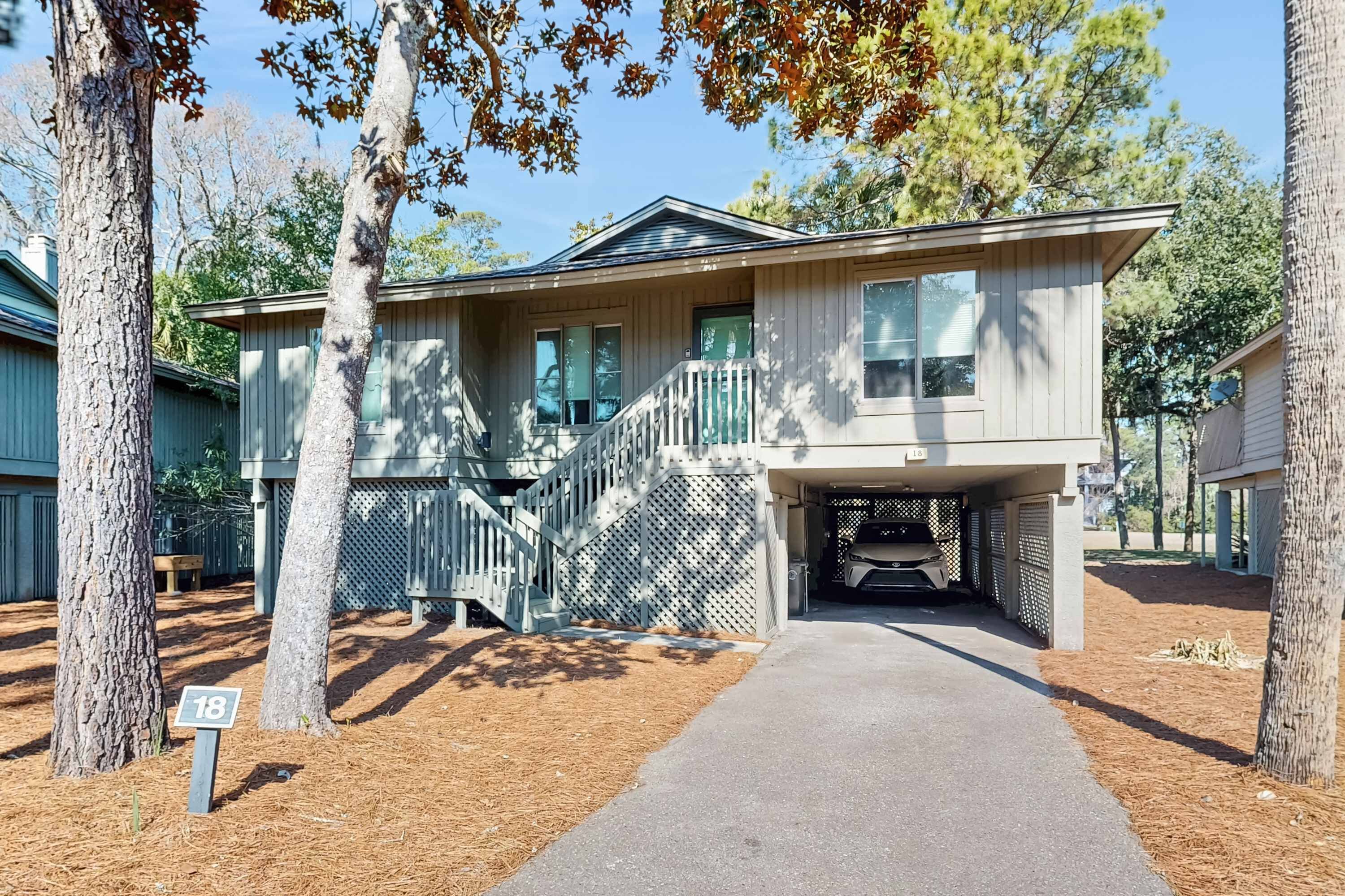 A two-story house with a covered garage, a front porch, and a driveway leading to the entrance.