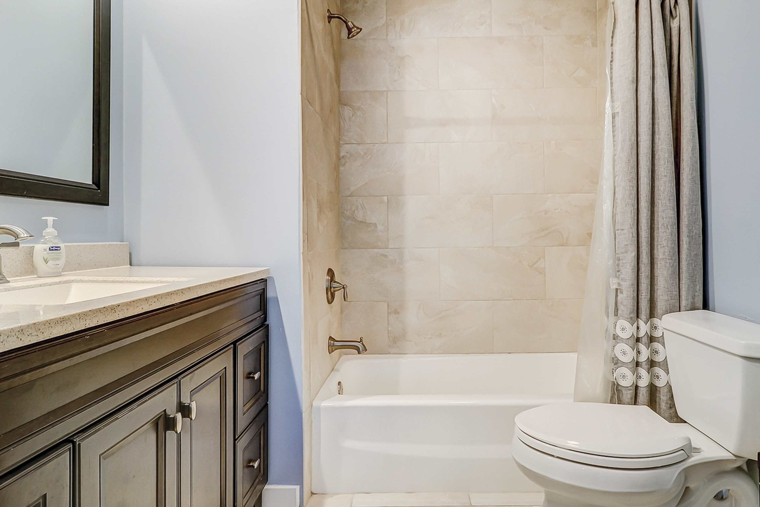 A bathroom with a bathtub, toilet, and sink.