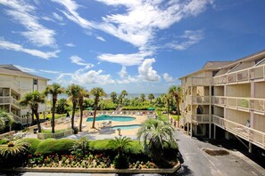 A hotel with a pool, palm trees, and a view of the ocean. - Beach-view condo in oceanfront complex with outdoor pool, beach access & balcony (Hilton Head)