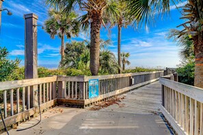 A wooden boardwalk with a sign indicating it is a pedestrian path. - Beach-view condo in oceanfront complex with outdoor pool, beach access & balcony (Hilton Head)