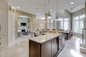 A spacious kitchen with a large island, pendant lighting, and a view to the dining area. - Close to beach, pickleball, tennis & golf with private pool, & hot tub (Hilton Head)