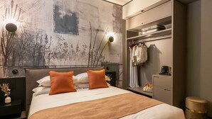 A modern hotel room with a large bed, a wardrobe, a nightstand, and a wall with a textured design. - Emotional Shower & Absolute Silence (Rome)