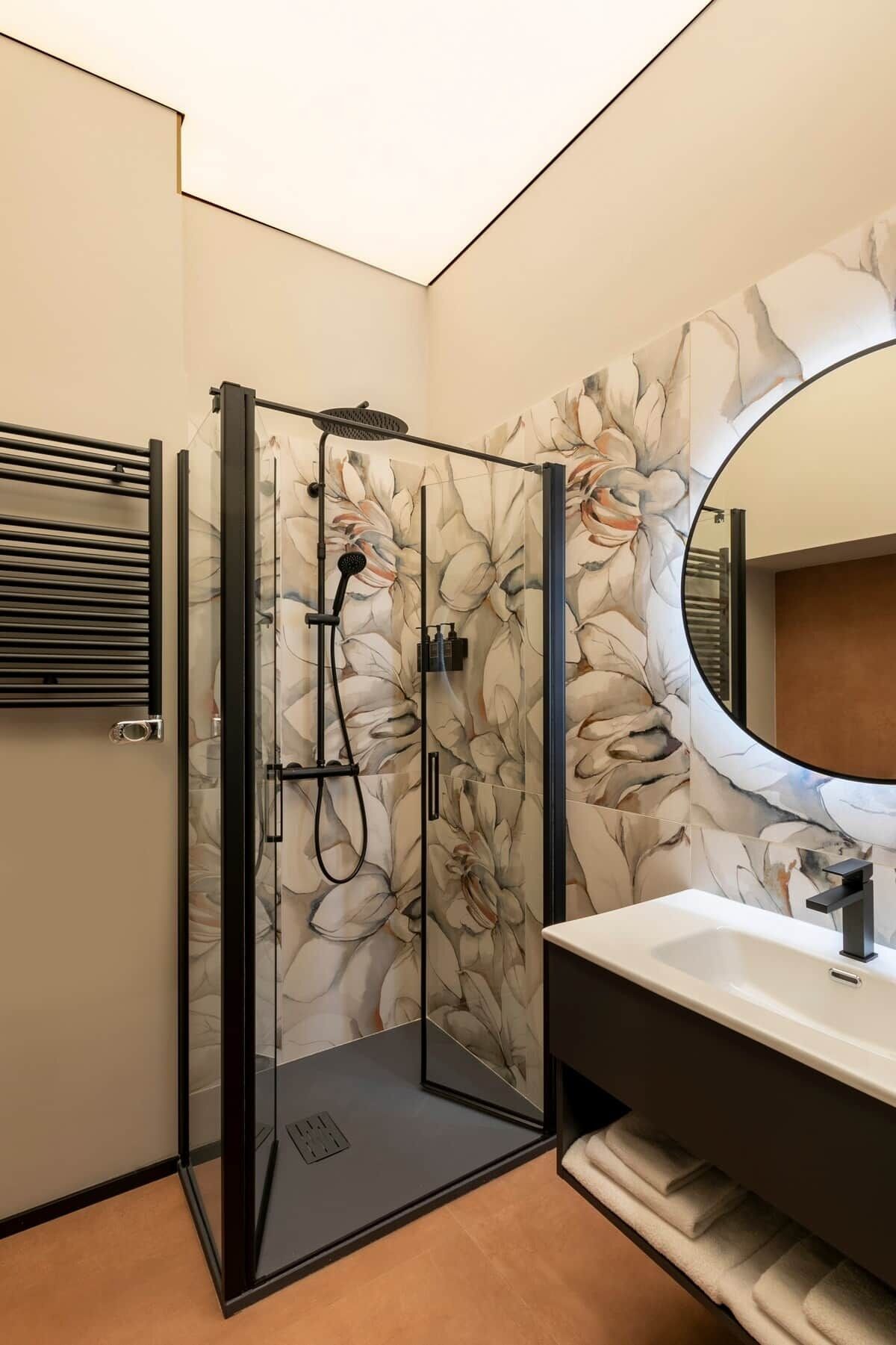 Une salle de bain moderne avec une douche à parois de verre, un grand miroir et un meuble-lavabo.