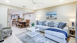 A living room with a sofa, coffee table, and dining area.