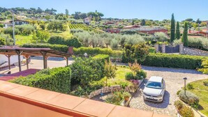 A residential area with a car parked in a driveway, surrounded by well-maintained gardens and a clear sky. - Il Favoloso Mondo di Vale (Marino)