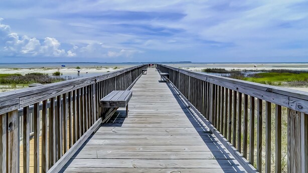 A wooden boardwalk leading to a beach with a clear sky. - Vibrant condo with tennis courts, pool, WD, gas grill, balcony, & playground (Hilton Head)