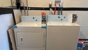 Two Whirlpool washing machines in a laundry room with a wall-mounted electrical outlet and a power strip. -  1-bedroom Temple near train and buses (Philadelphia)