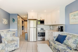 A compact living space with a kitchenette, a dining area, and a sofa. - Oceanfront resort condo with WiFi, balcony, pool, grills, & beach access (Hilton Head)