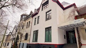 Un bâtiment à la façade blanche, aux ornements noirs et au toit rouge.