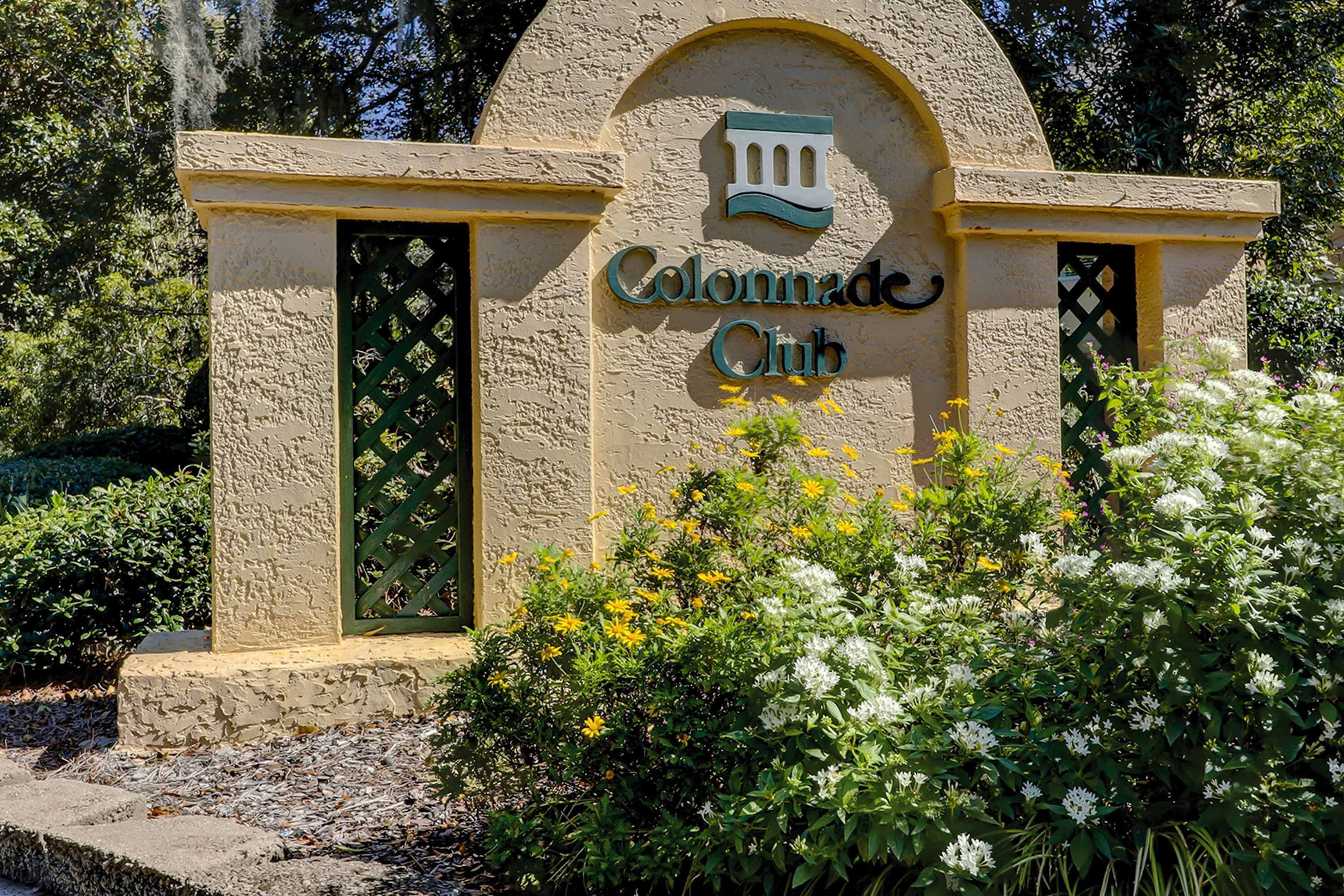 Un edificio con un letrero que dice 'Colonnade Club' y un arco decorativo.