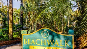 A sign for 'Beachwalk Private' with a number '125' and a compass symbol, surrounded by lush greenery. - Dog Friendly Villa with Walkable Beach Access, AC, Deck, WiFi & Shared Pool (Hilton Head)