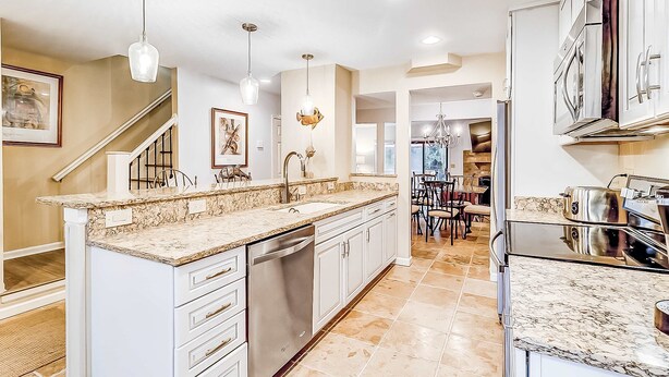 A modern kitchen with a central island, stainless steel appliances, and pendant lighting. - Dog Friendly Villa with Walkable Beach Access, AC, Deck, WiFi & Shared Pool (Hilton Head)