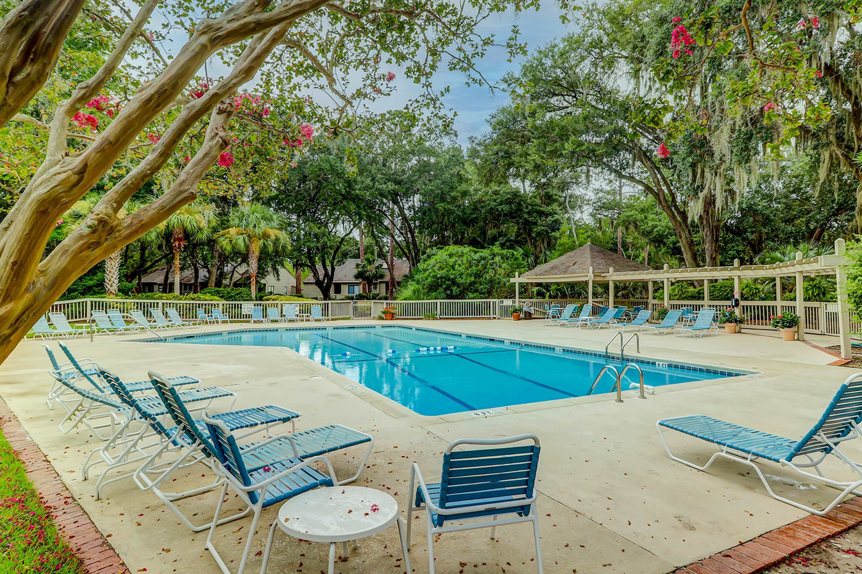 A swimming pool with lounge chairs and a gazebo.