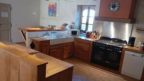 Une cuisine avec des meubles de rangement en bois, une cuisinière, un four à micro-ondes et un évier.