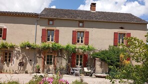 A two-story building with red shutters, a tiled roof, and a garden with outdoor furniture. - Cottage for 6 People in the Tarn Countryside (Andouque)