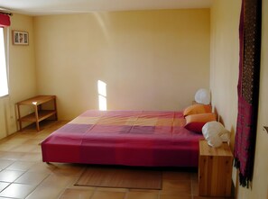 A bedroom with a bed, a nightstand, a window, and a door. - Cottage for 6 People in the Tarn Countryside (Andouque)