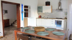 A modern kitchen with white cabinets, a gas stove, and a built-in oven.