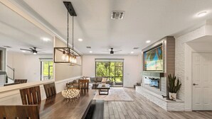 Una cocina amplia con comedor, ventanas grandes y chimenea.