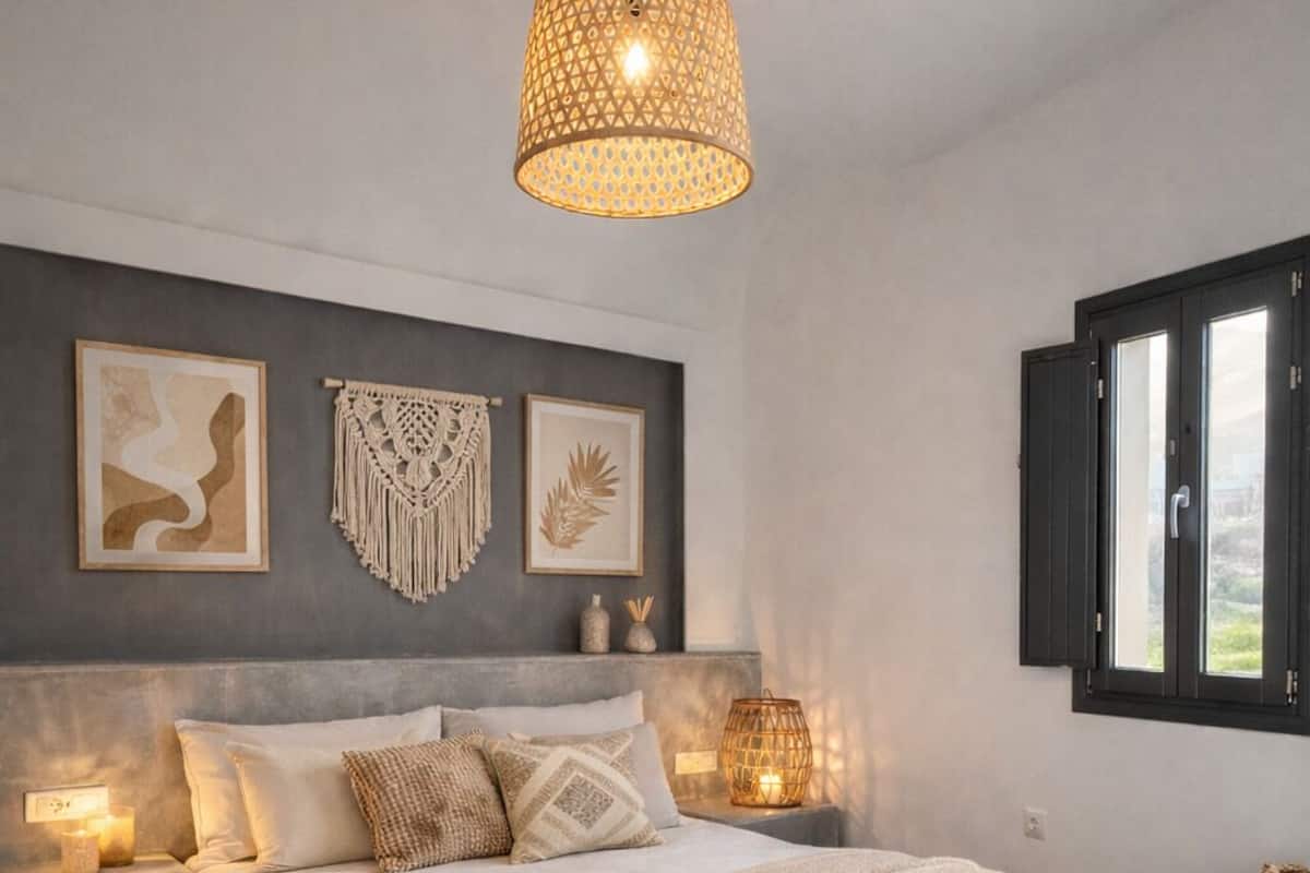 A bedroom with a bed, bedside lamps, wall art, and a window.