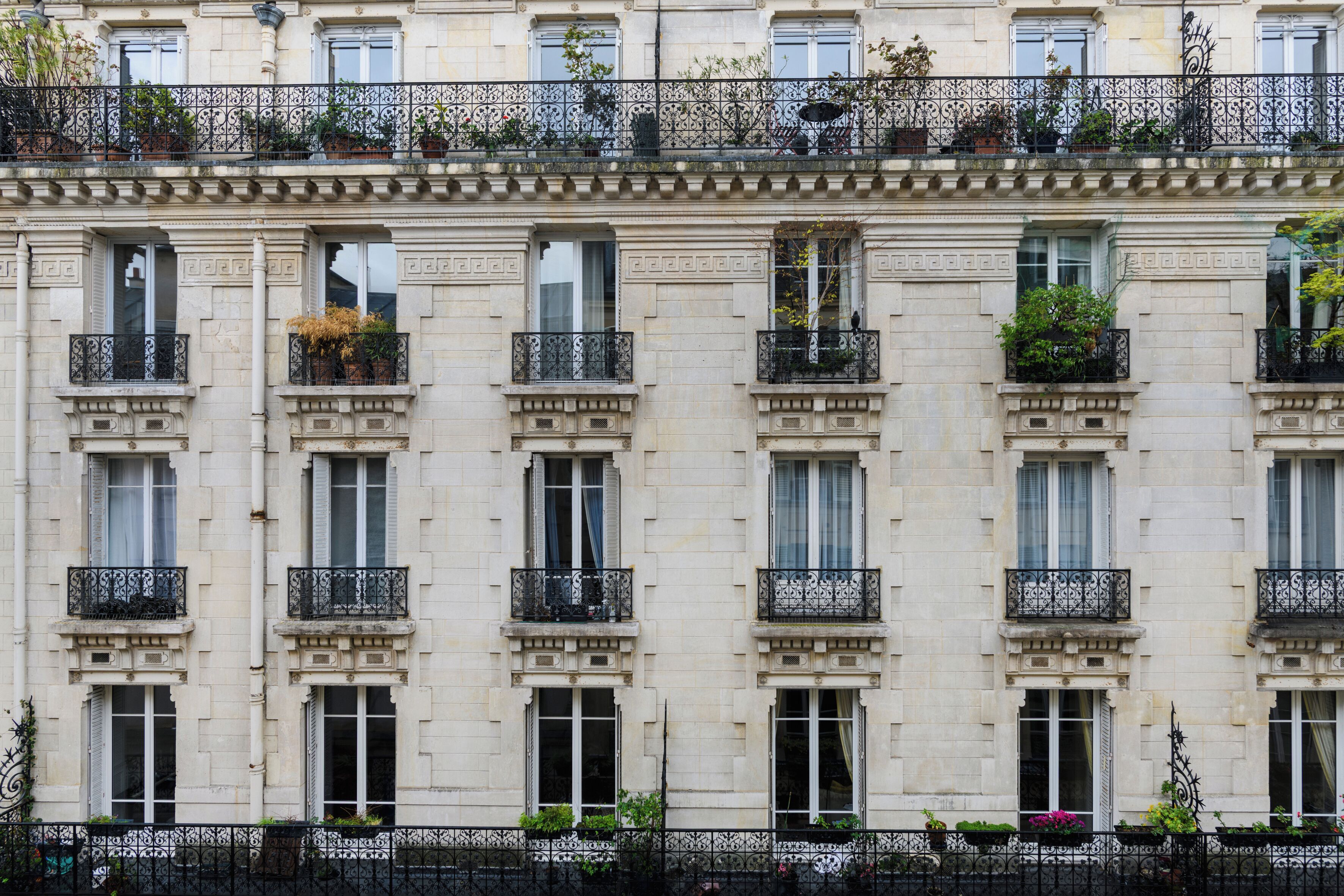 Un edificio de varios pisos con balcones ornamentados, ventanas amplias y un estilo arquitectónico clásico.