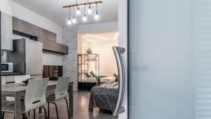 Eine moderne Küche mit Essbereich, ein Bett mit Blick und eine Glasabtrennung.