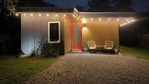 A modern house with a gravel driveway, a red door, and outdoor seating. - Red Door Retreat- 1 mile to downtown St. Augustine! Pet-friendly! New on market! (St. Augustine)