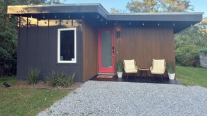 A modern house with a red door, two chairs, and a small table outside. - Red Door Retreat- 1 mile to downtown St. Augustine! Pet-friendly! New on market! (St. Augustine)