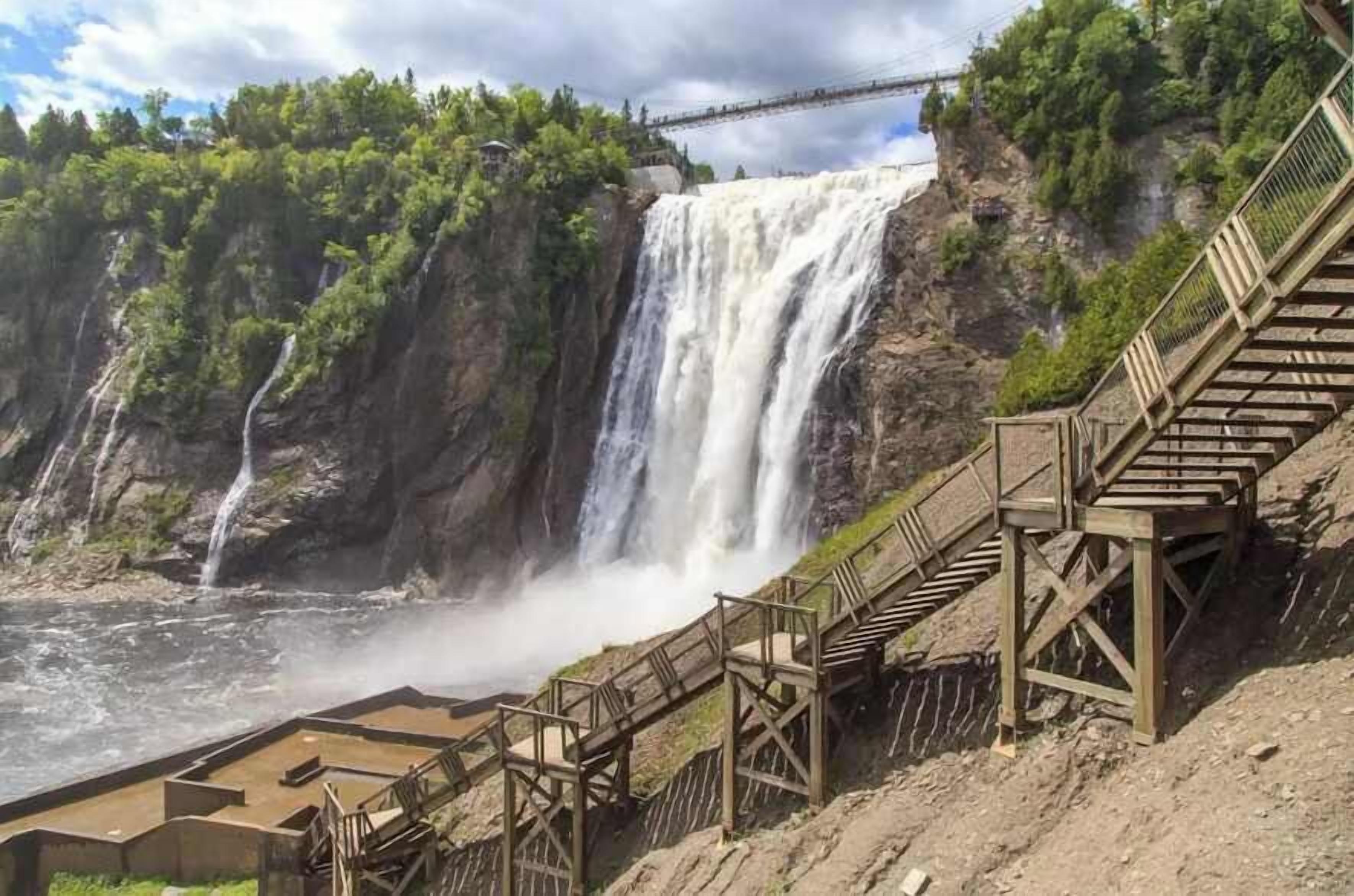 Una cascada con una escalera de madera que conduce a una plataforma de observación.