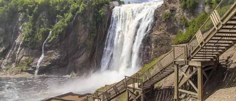 Una cascada con una escalera de madera que conduce a una plataforma de observación.