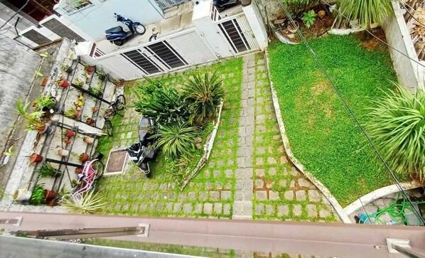 Un patio con suelo empedrado, plantas en macetas y una moto.