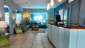 A modern living room with a sofa, a coffee table, a lamp, and a TV. - Days Inn By Wyndham Playa Del Carmen (Playa del Carmen)