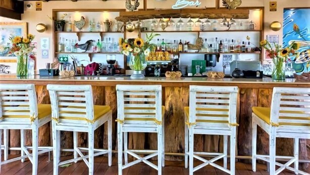A rustic bar area with wooden beams, a neon sign reading 'Bee Bar', and a bar counter with various bottles and a coffee machine. - Days Inn By Wyndham Playa Del Carmen (Playa del Carmen)