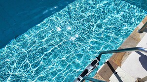 A clear pool with visible water ripples and a metal ladder leading into it. - Days Inn By Wyndham Playa Del Carmen (Playa del Carmen)