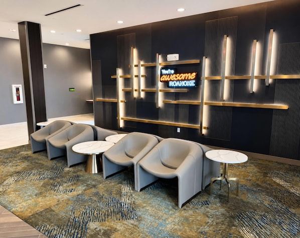 Un'area lounge moderna con posti a sedere e un neon.