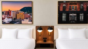 A hotel room with two beds, a nightstand with a lamp, and two framed pictures on the wall. - La Quinta Inn & Suites By Wyndham Roanoke Hollins/I-81 (Roanoke)