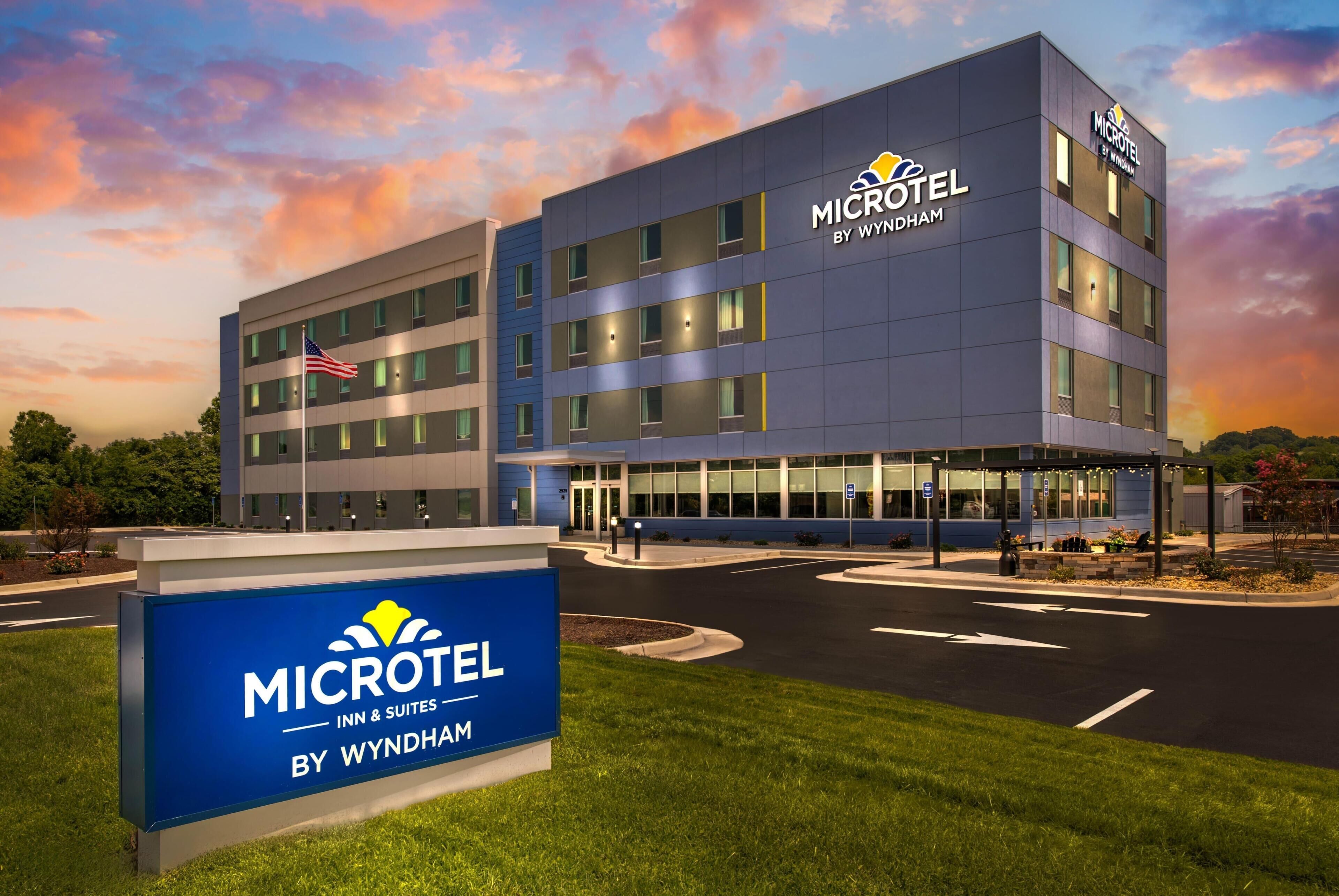 Un bâtiment de la chaîne Microtel Inn & Suites by Wyndham, avec un ciel dégagé et un drapeau américain.