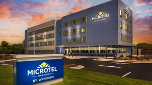 Un bâtiment de la chaîne Microtel Inn & Suites by Wyndham, avec un ciel dégagé et un drapeau américain.