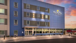 Un hôtel Microtel moderne de la chaîne Wyndham, caractérisé par une façade sobre, de grandes fenêtres et un ciel dégagé.