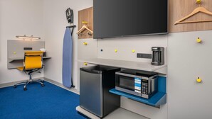 Une petite cuisine équipée d’un four à micro-ondes, d’une machine à café et d’un petit réfrigérateur.