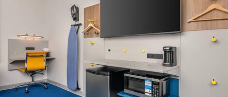 A compact kitchenette with a microwave, coffee maker, and a small refrigerator.