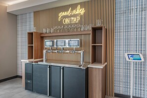 A bar area with a neon sign, multiple taps, and a wine glass display. - Microtel Inn & Suites By Wyndham Danville Va (Danville)