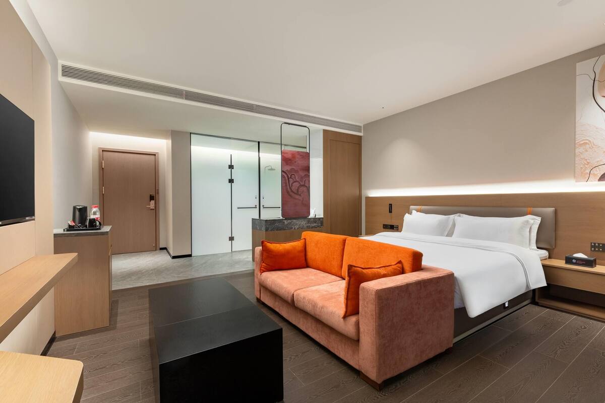 Een hotelkamer met een bed, een bank, een bureau en een televisie.