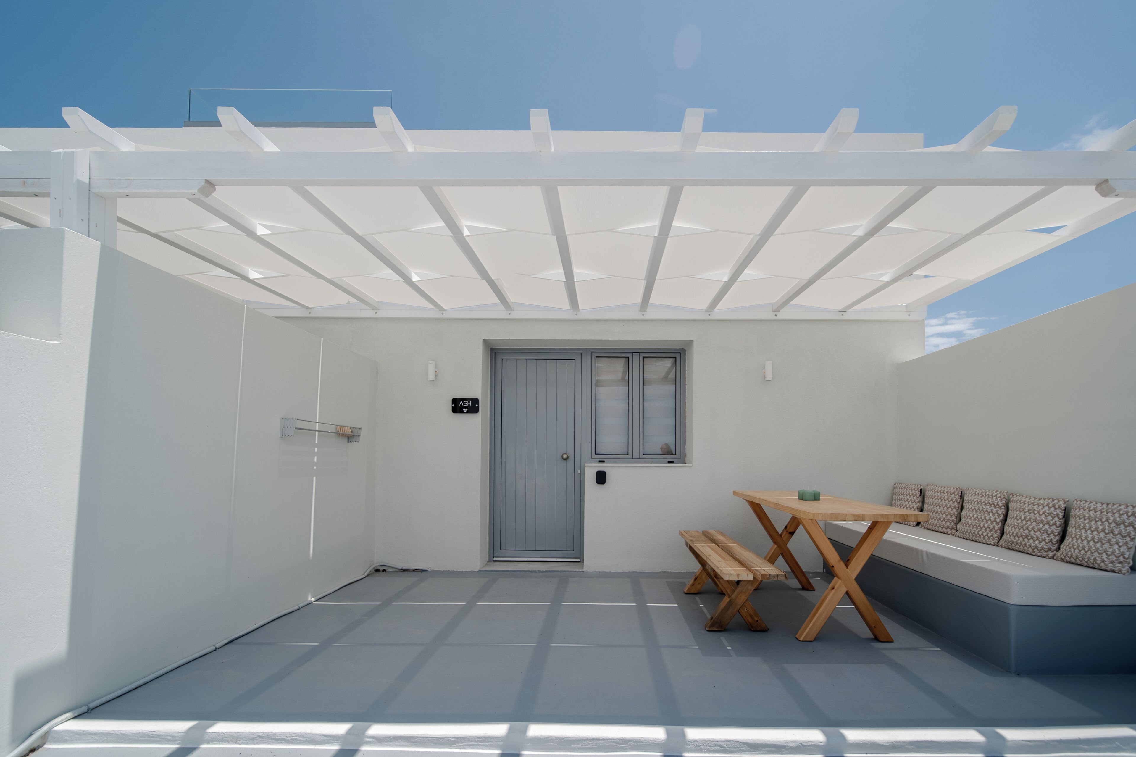 A covered outdoor area with a door, a bench, and a sofa.