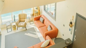Um interior moderno com um conjunto de sofá, uma poltrona, uma mesinha e um armário.