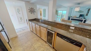 A modern kitchen with granite countertops, wooden cabinets, and a dishwasher. - Family Fun Condo Near Private Beach Silver Dunes 48 (Destin)