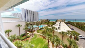 A hotel with a pool, palm trees, and a view of the ocean. - Family Fun Condo Near Private Beach Silver Dunes 48 (Destin)
