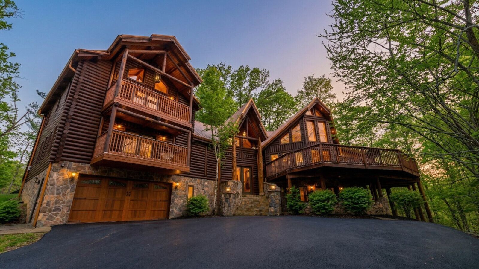 Grand log cabin exterior surrounded by trees, setting the scene for a spacious mountain retreat and unforgettable group vacation