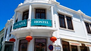A white building with a curved corner, a sign reading 'CASA AZUL HOSTEL,' and a 'RESTAURANTE' sign below. - Casa Azul Hostel (Sintra)
