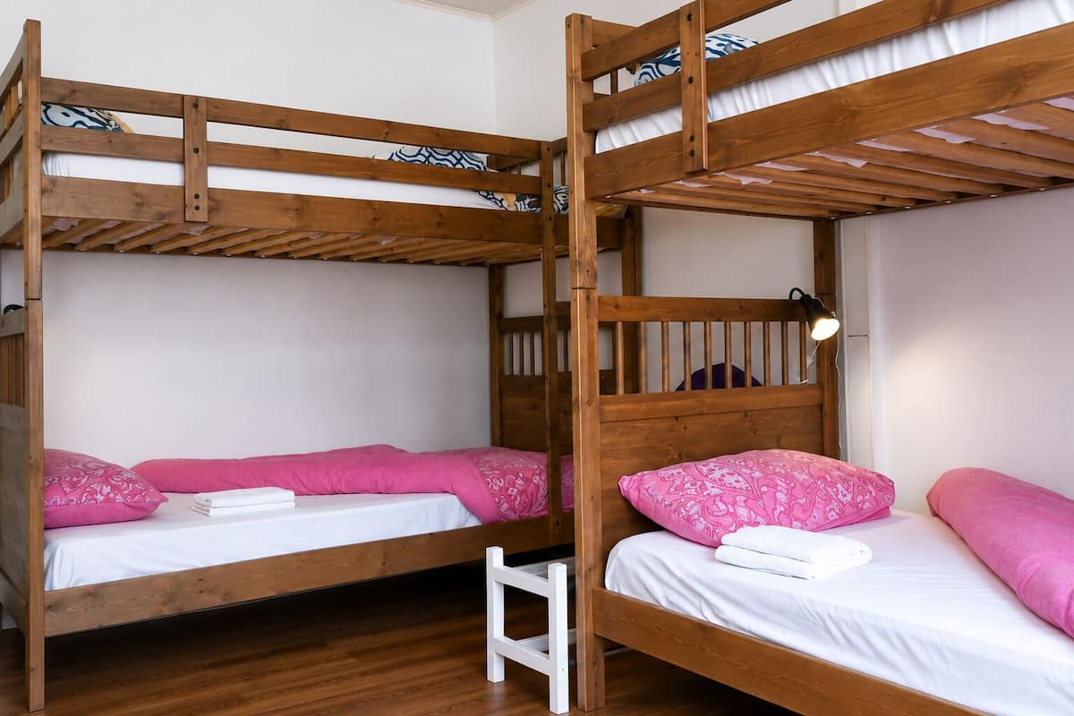Habitación con literas, dos camas, cada una con almohada y manta.