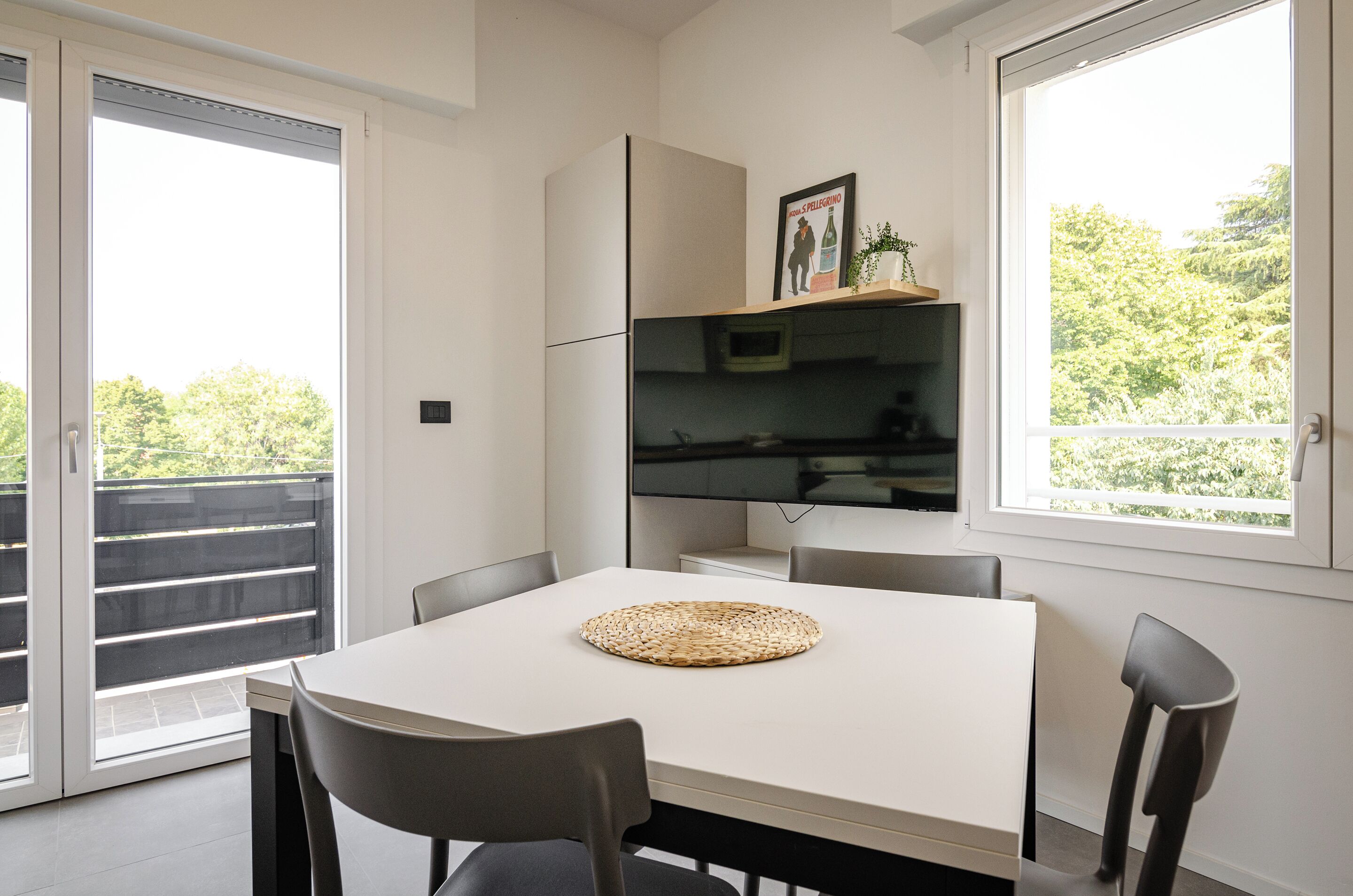 A modern kitchen with a white countertop, a woven placemat, and a built-in microwave.
